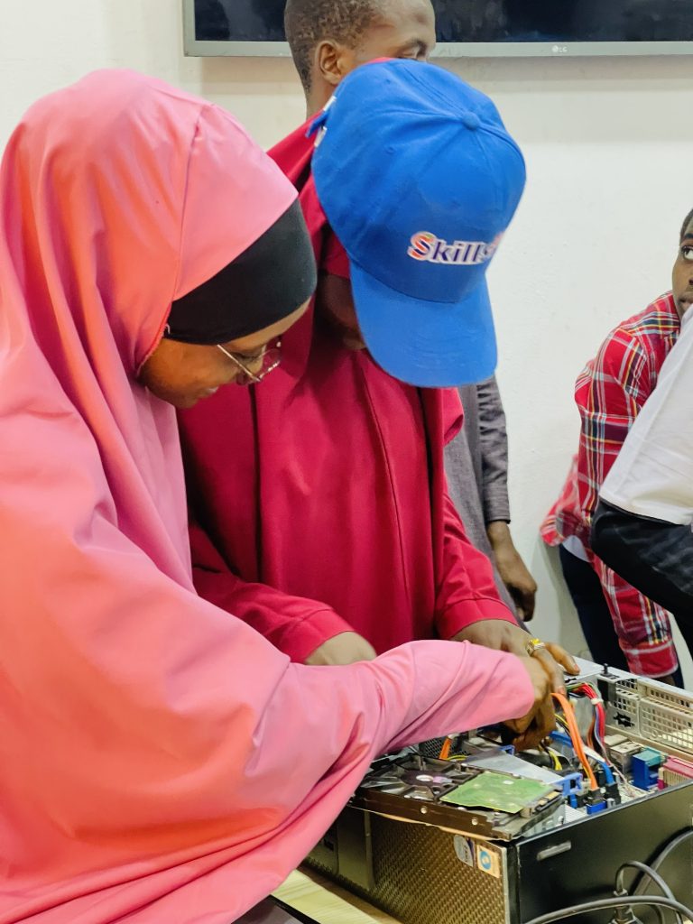 A female SkillsPark participant working with computer hardware during practical training.