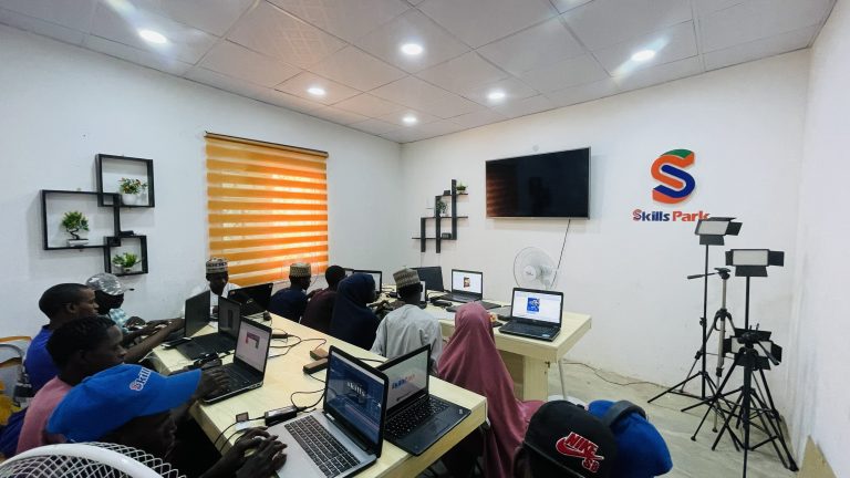 A SkillsPark learning space with participants working on laptops.
