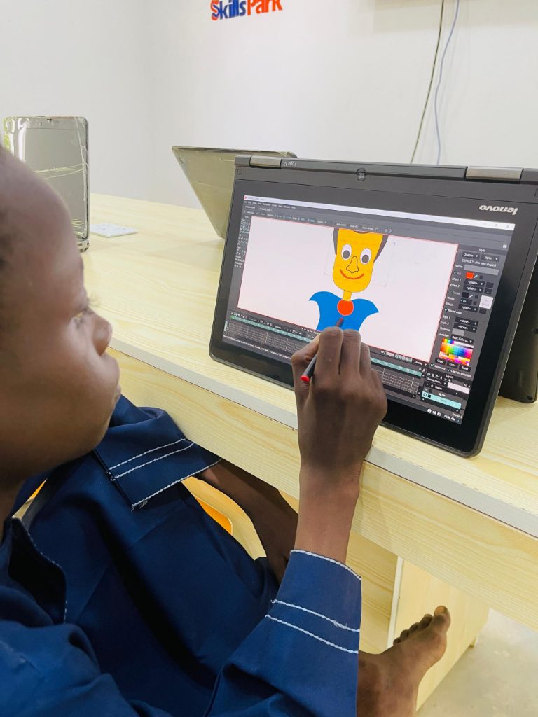A young SkillsPark learner using a laptop and stylus to create a 2D animation.